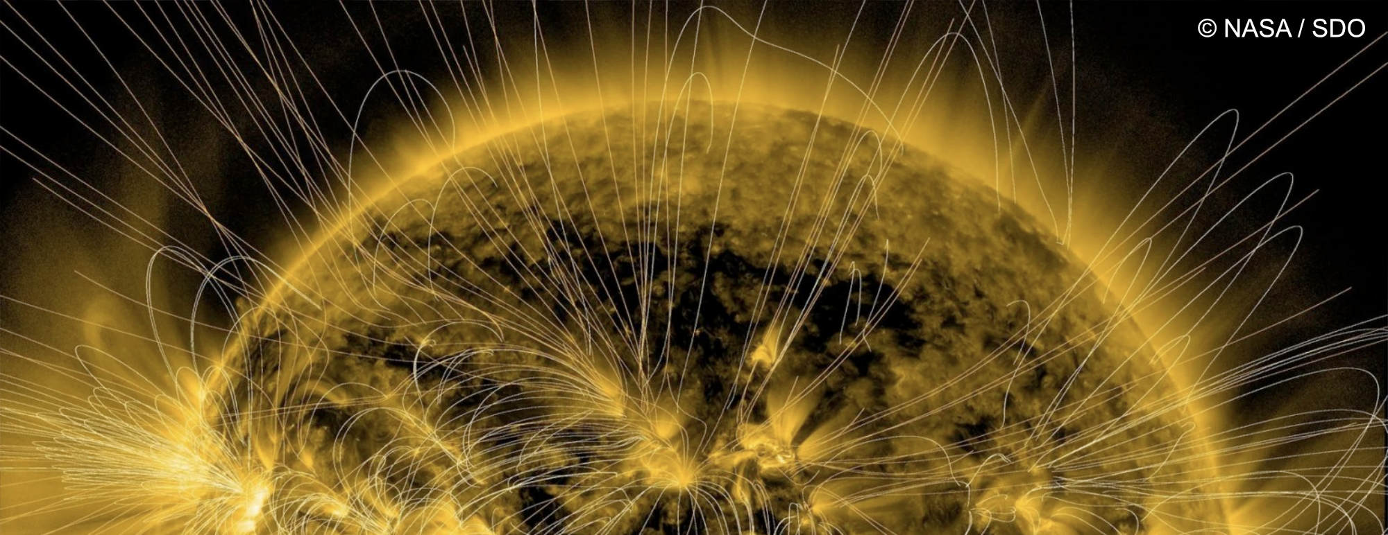Sonnenstürme: Simulation von gebogenen Magnetfeldelinien über der Phospähre der Sonne.